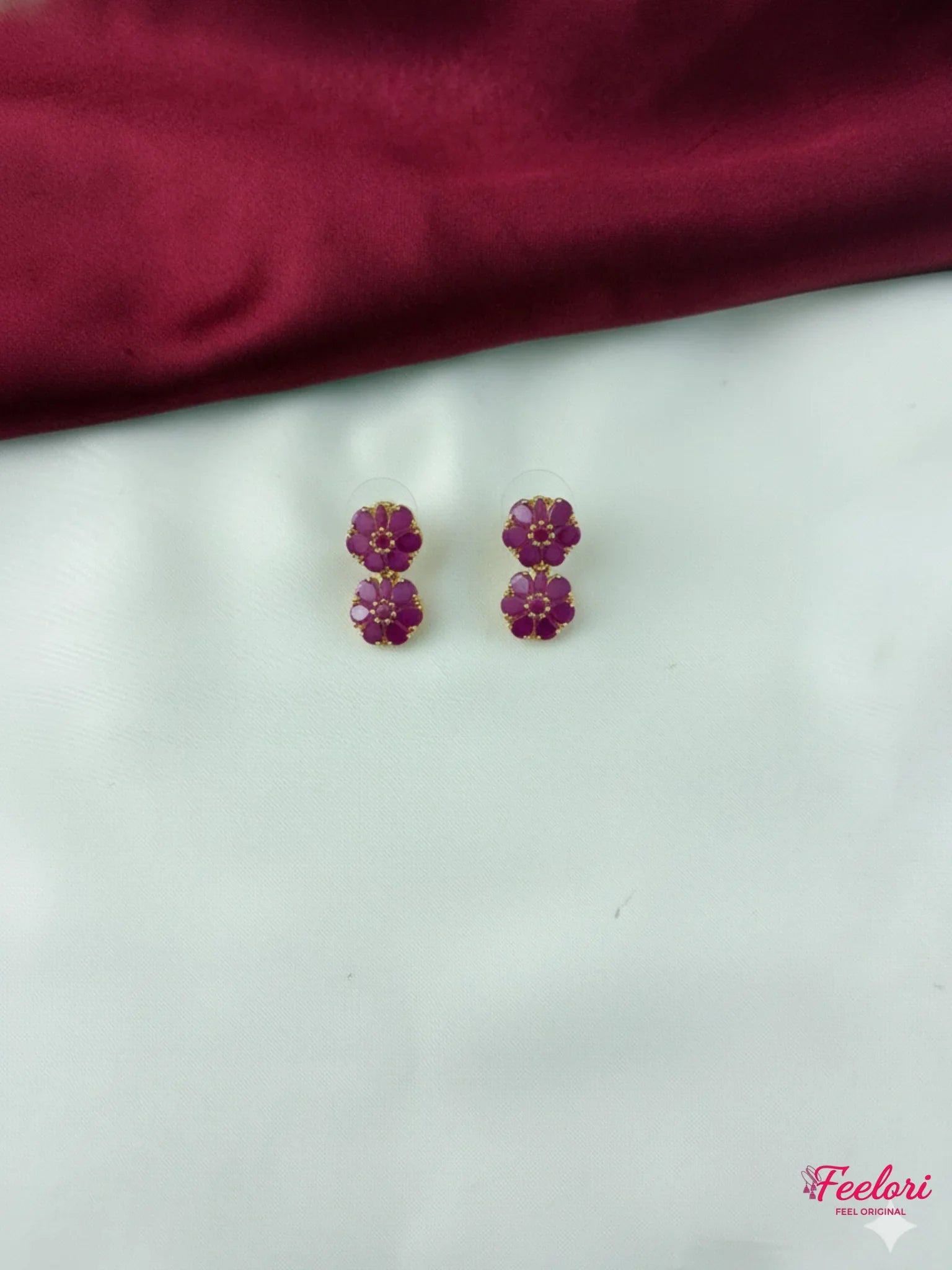 FeelOri Gold Plated Ruby Dual Flower Earrings - Close-up view highlighting the intricate two-tiered floral design and vibrant ruby-hued stones.