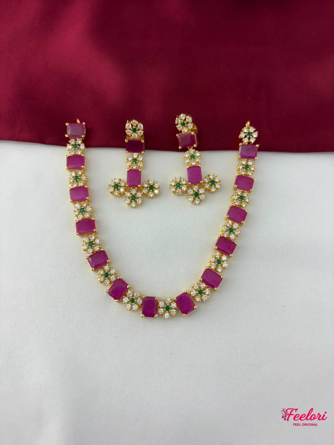 FeelOri Gold Plated Ruby Emerald Floral Necklace Set - flat lay view showcasing the full necklace with rectangular ruby segments and matching floral cluster earrings.