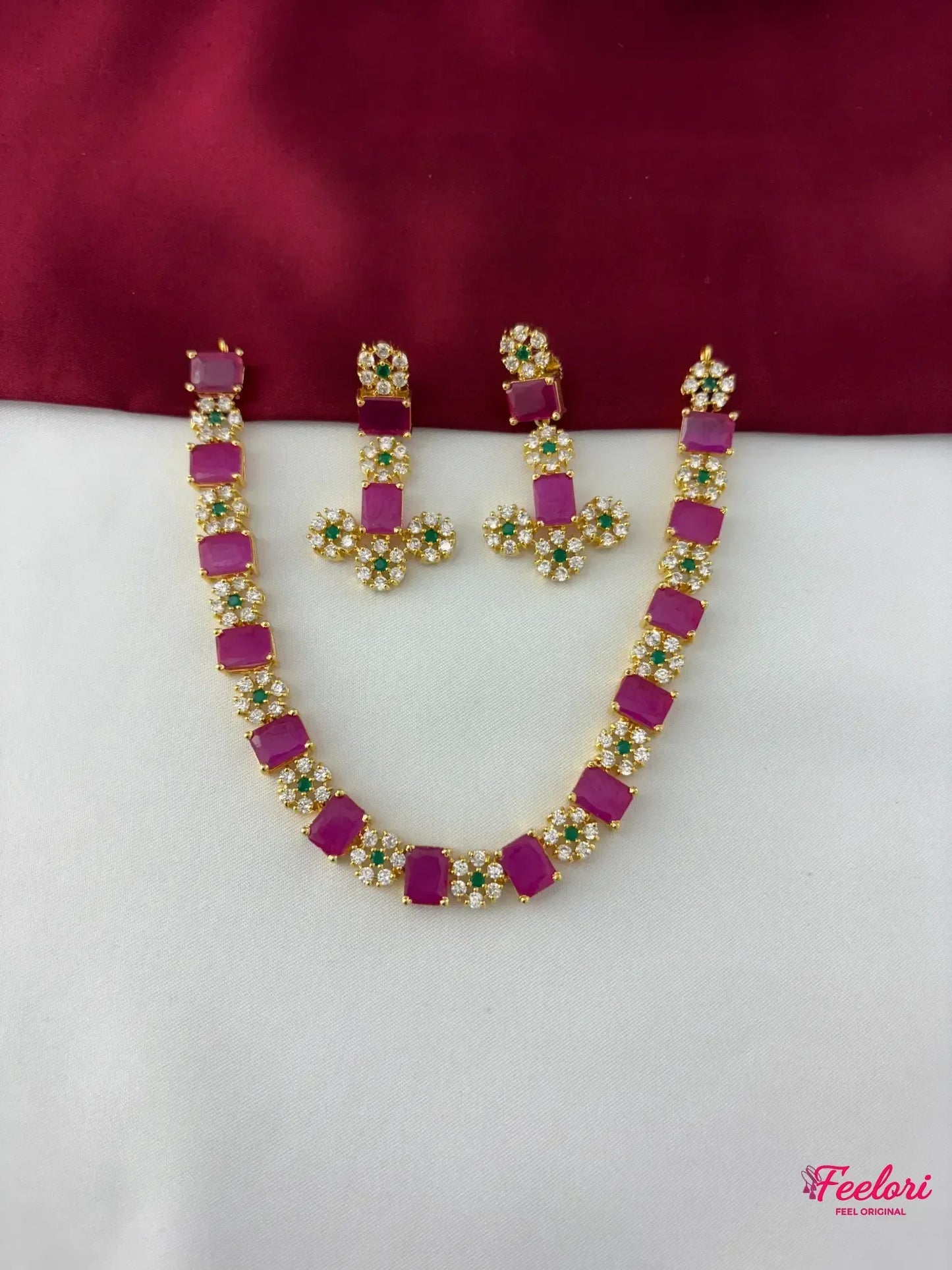 FeelOri Gold Plated Ruby Emerald Floral Necklace Set - flat lay view showcasing the full necklace with rectangular ruby segments and matching floral cluster earrings.