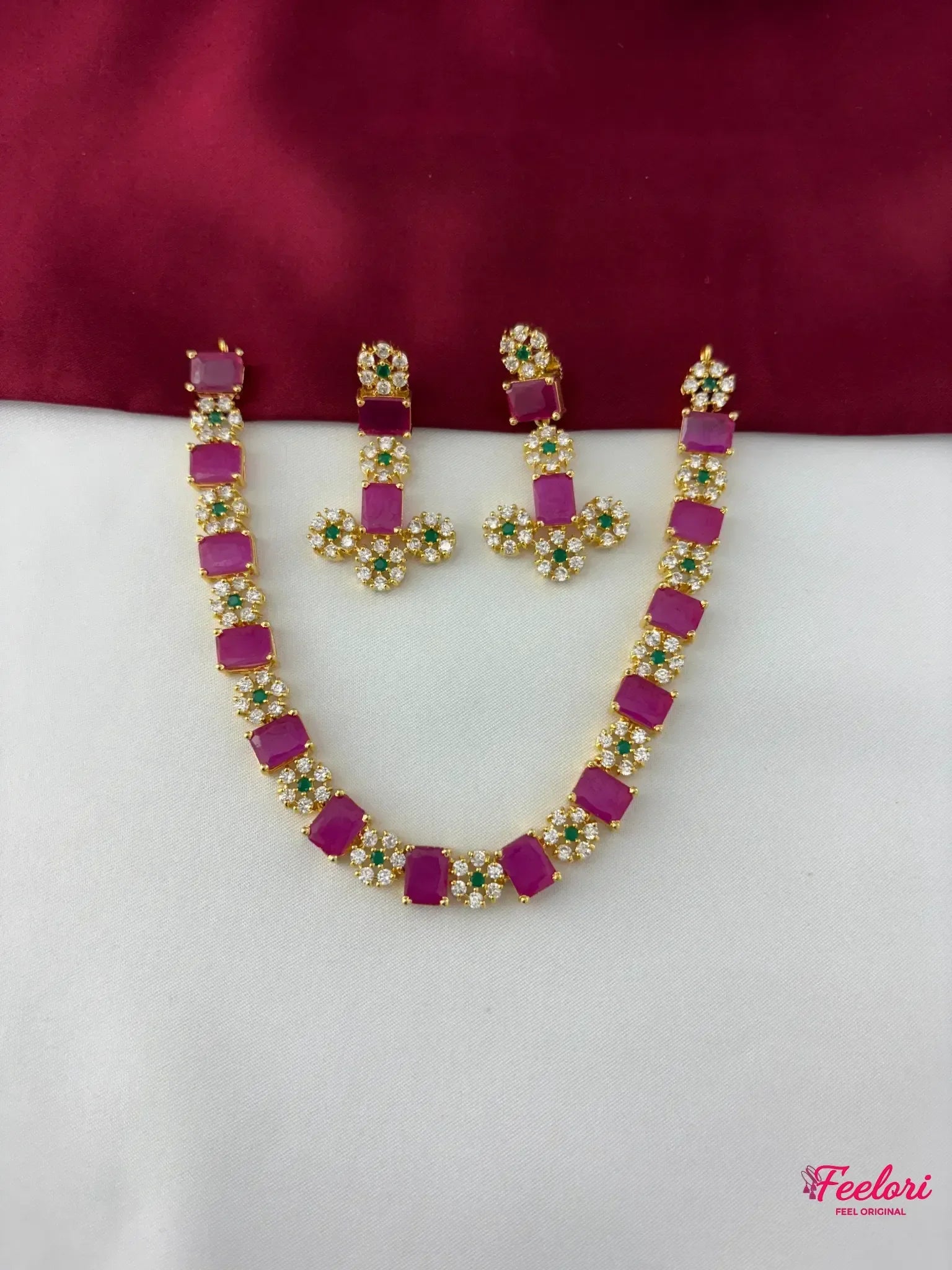 FeelOri Gold Plated Ruby Emerald Floral Necklace Set - flat lay view showcasing the full necklace with rectangular ruby segments and matching floral cluster earrings.