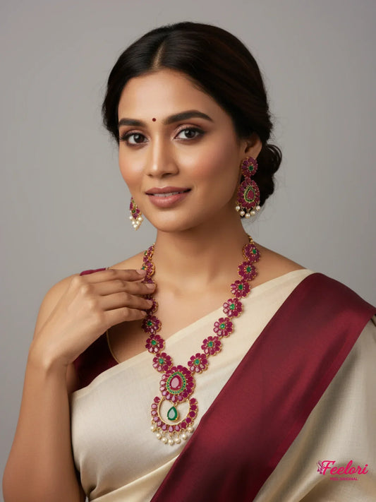 FeelOri Gold Plated Floral Ruby Emerald Necklace Set - Model wearing set with traditional ivory and maroon saree.