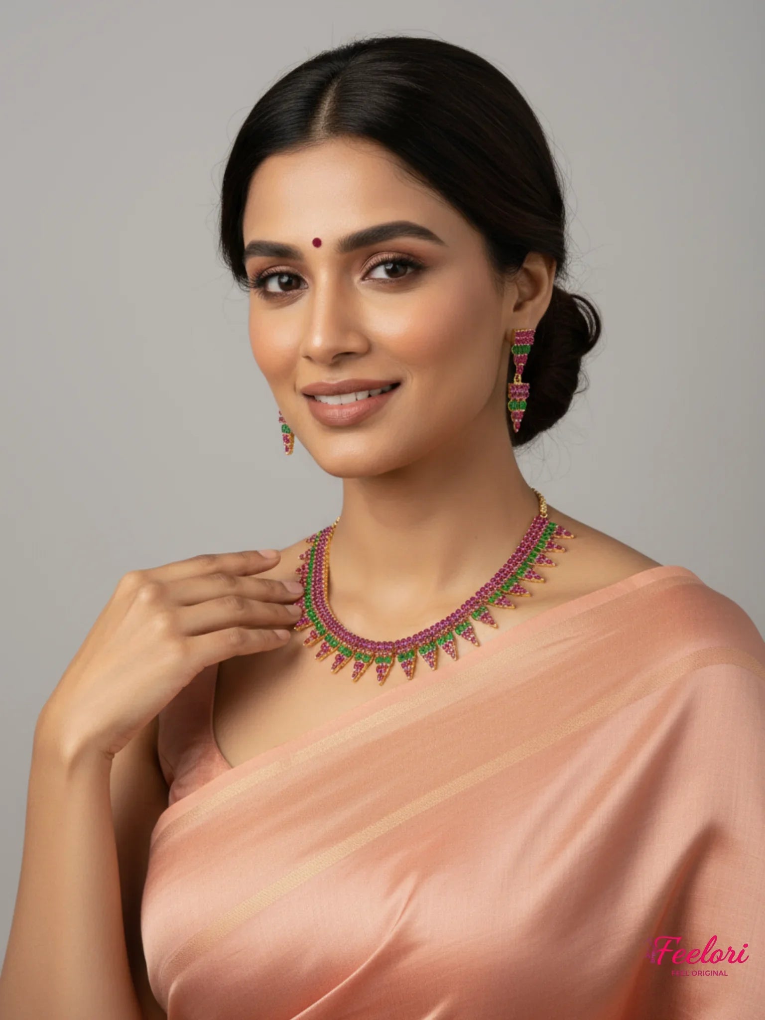 FeelOri Gold Plated Ruby Emerald Layered Necklace Set - Model wearing vibrant set with traditional peach sari