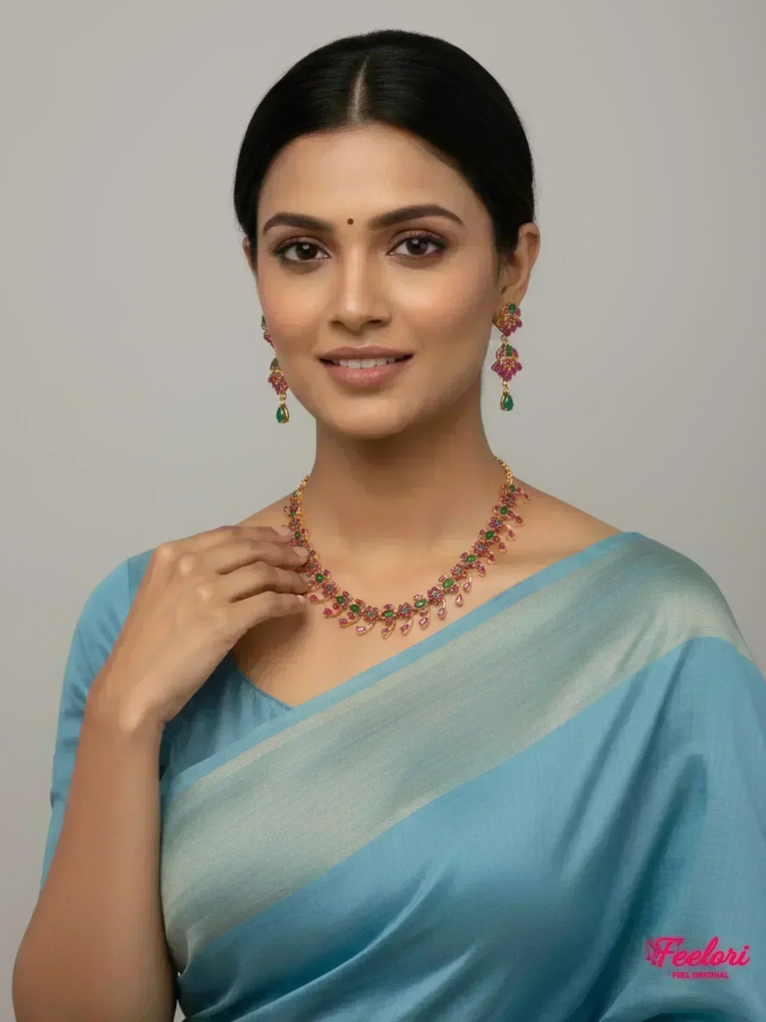 FeelOri Gold Plated Ruby Emerald Necklace Set - Model wearing elegant set with blue traditional saree