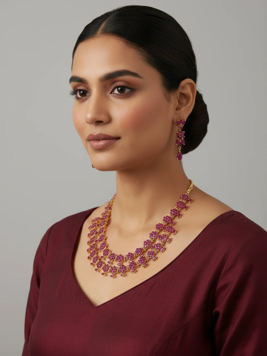FeelOri Gold Plated Ruby Floral layered necklace set. Model wearing elegant set with maroon top.