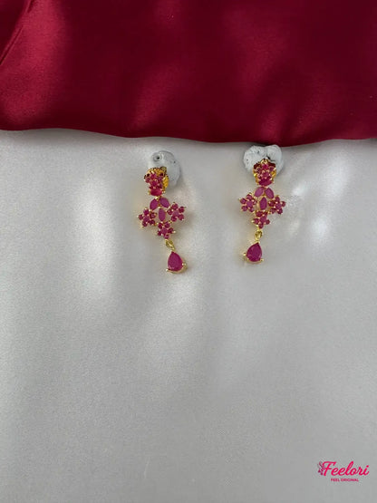 FeelOri Gold Plated Ruby Floral Earrings - Close-up view highlighting the intricate floral cluster design and the dangling pear-shaped ruby-toned stone.