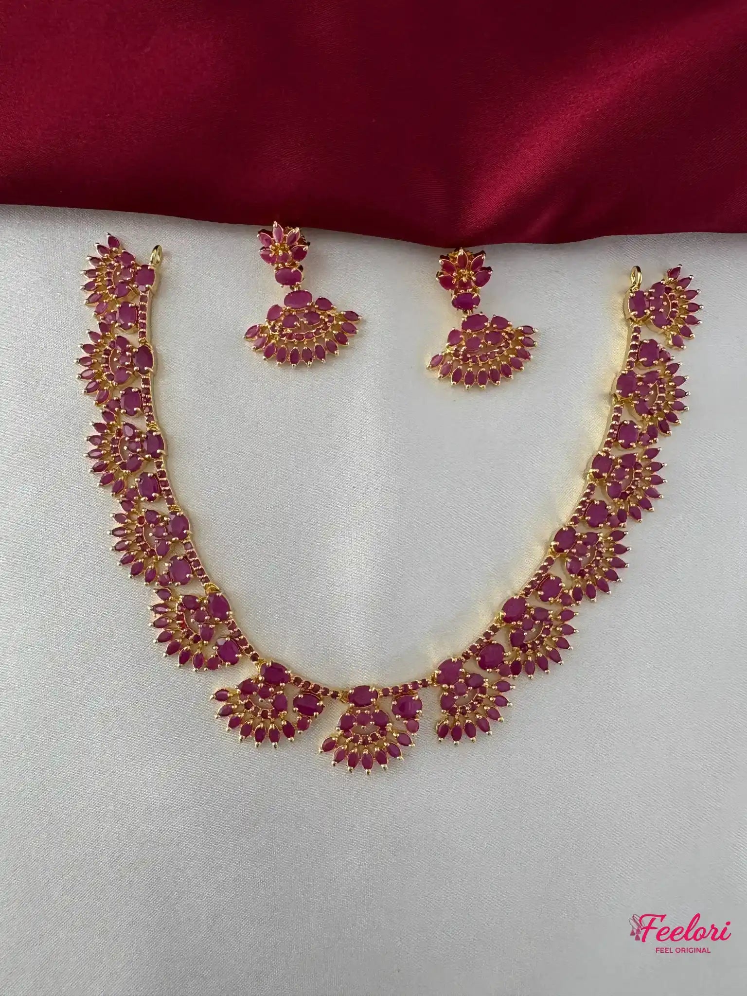 FeelOri Gold Plated Ruby Floral Necklace Set - Front view showcasing the intricate ruby-hued stone arrangements on both the necklace and matching earrings.