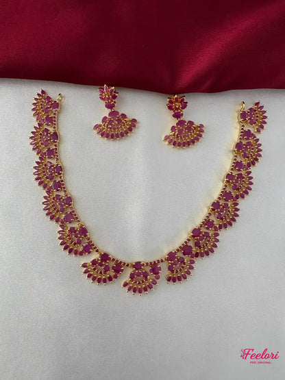 FeelOri Gold Plated Ruby Floral Necklace Set - Front view showcasing the intricate ruby-hued stone arrangements on both the necklace and matching earrings.