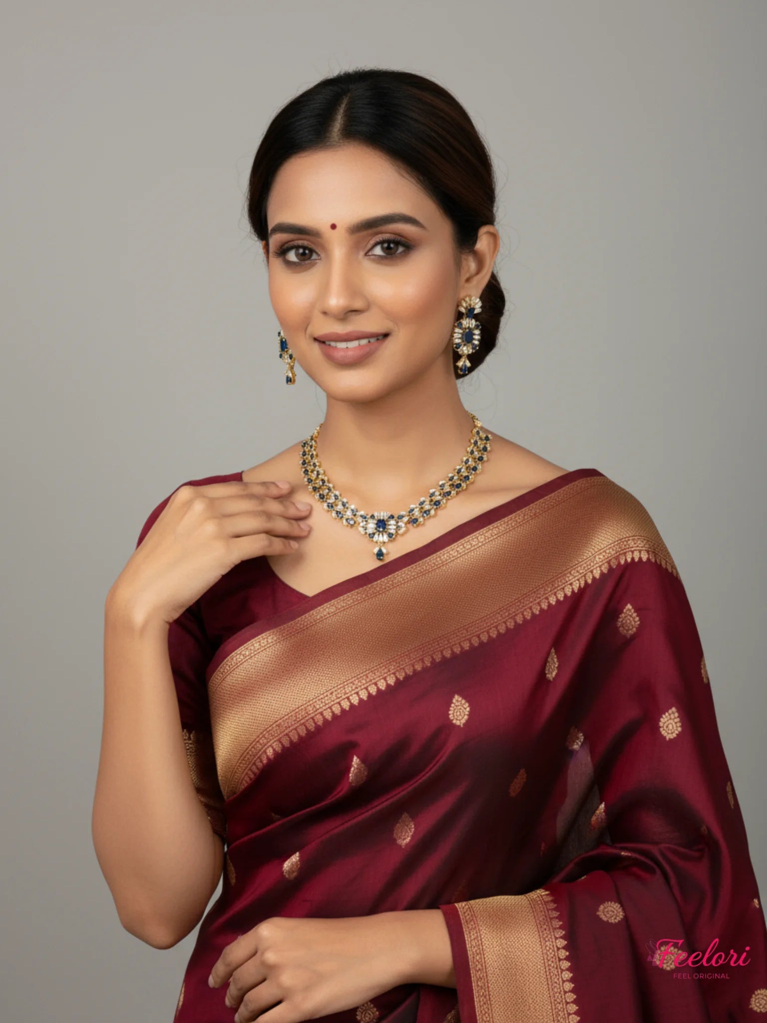 FeelOri Necklace Set - Model wearing gold plated sapphire & AD set with a traditional maroon saree in a studio.