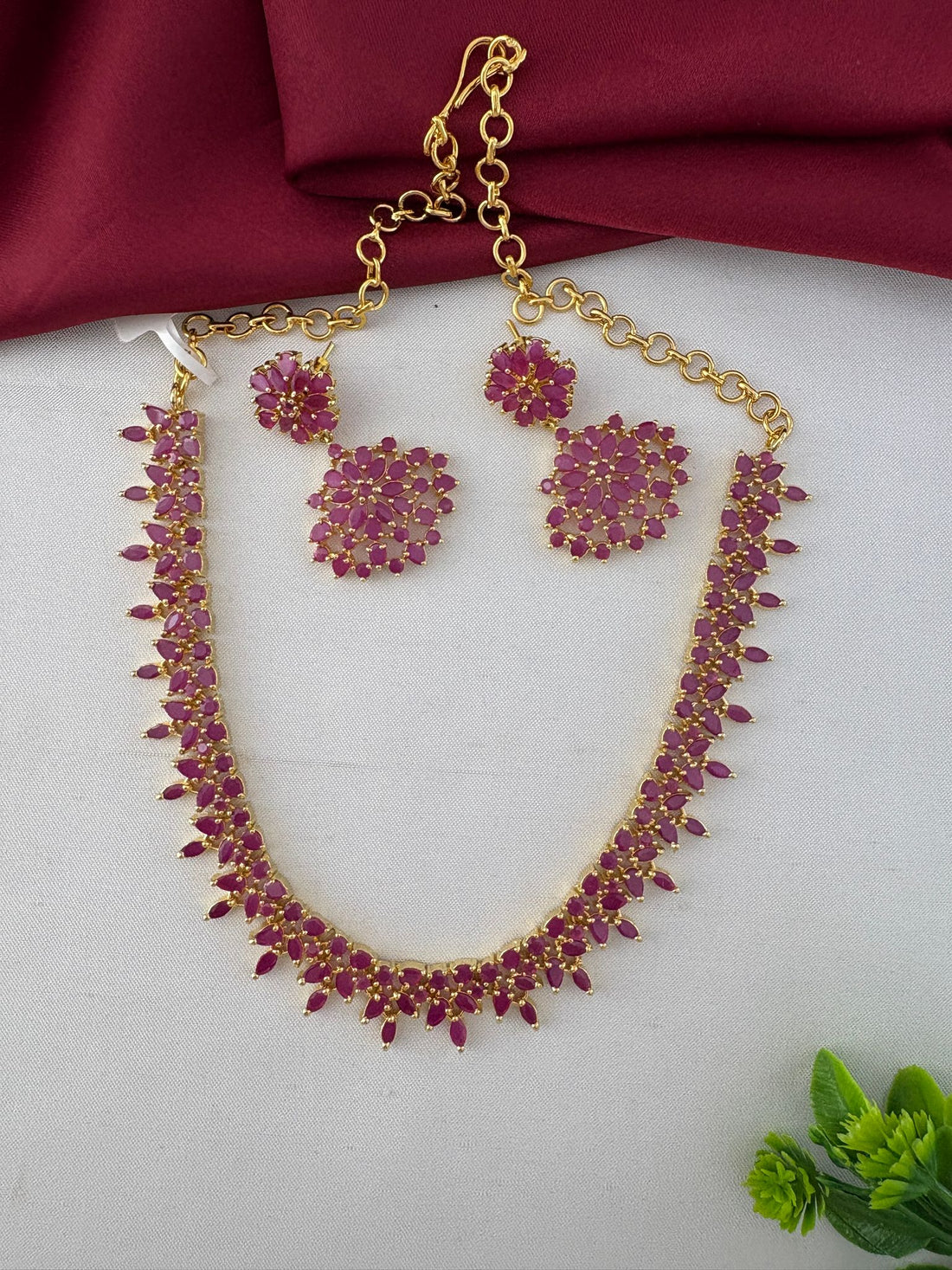 Full view of the Feelori Gorgeous Ruby-Tone CZ Short Necklace Set with earrings, displaying the chain and clasp detail, perfect for celebrations.