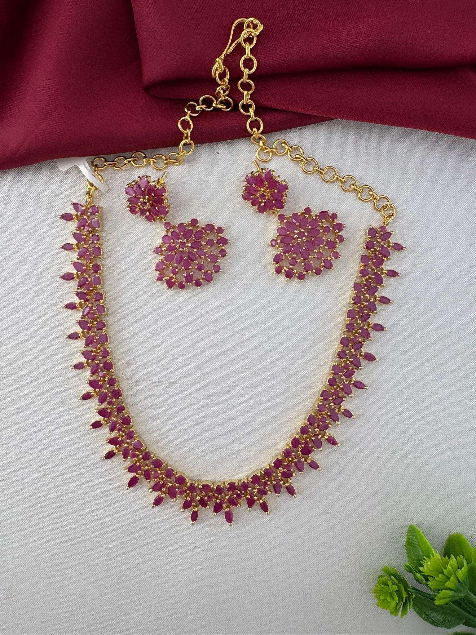 Full view of the Feelori Gorgeous Ruby-Tone CZ Short Necklace Set with earrings, displaying the chain and clasp detail, perfect for celebrations.