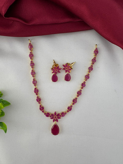 FeelOri Heritage Ruby-Tone CZ Short Necklace Set - Full view of necklace and earrings on a white and maroon background.