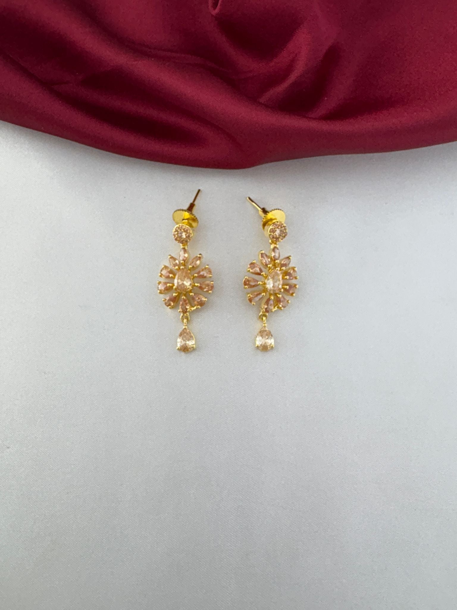 Detailed close-up of the earrings from the FeelOri Modern Aura Gold AD Geometric Short Pendant Set, highlighting the stone-studded floral pattern and drop stone.