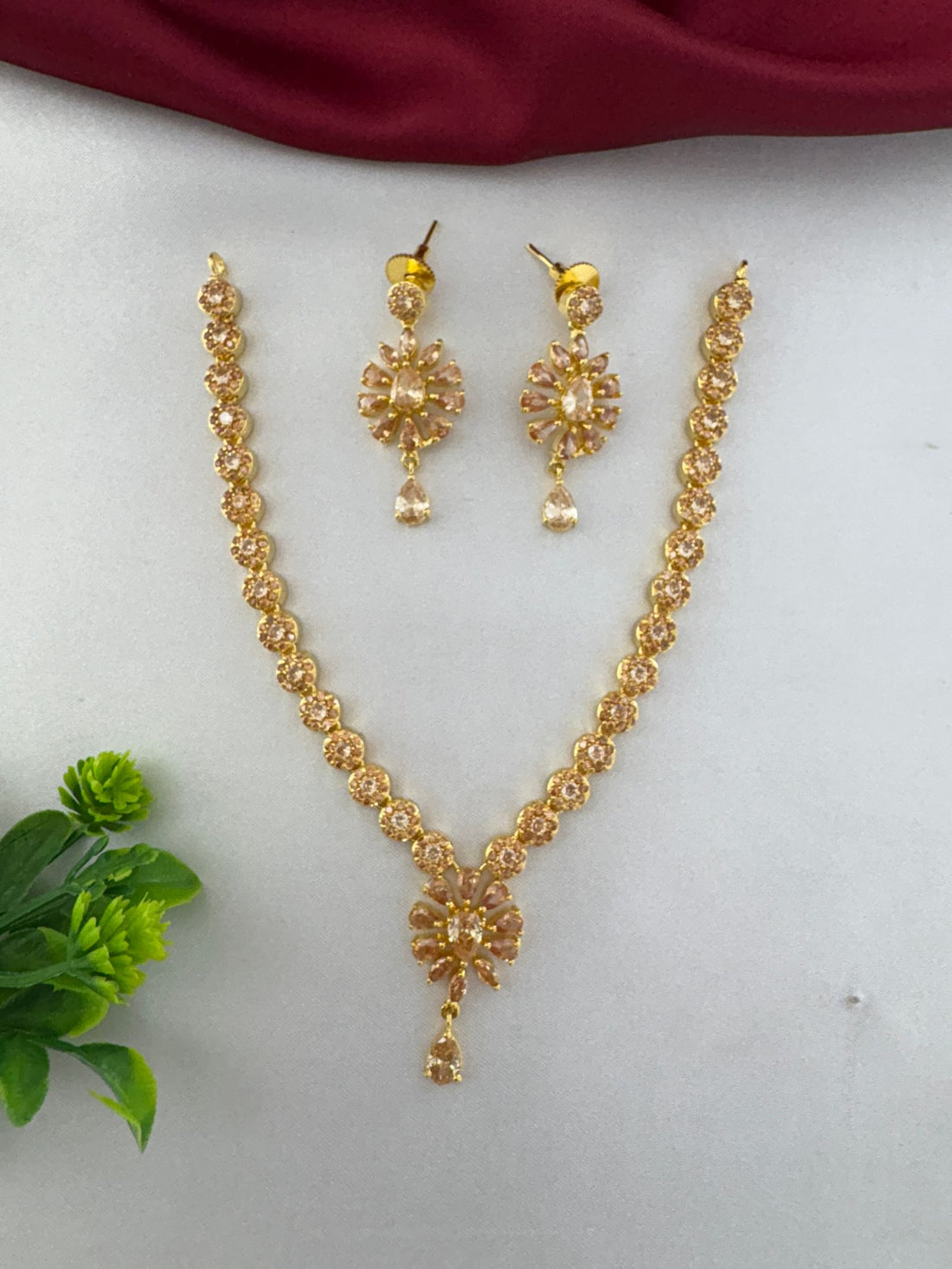 Full view of the FeelOri Modern Aura Gold AD Geometric Short Pendant Set, showcasing the necklace and matching earrings with intricate floral stone design.
