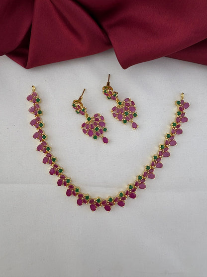 FeelOri Mysore Vasantham Ruby & Emerald Short Necklace Set with matching earrings, full view on a white and maroon background.