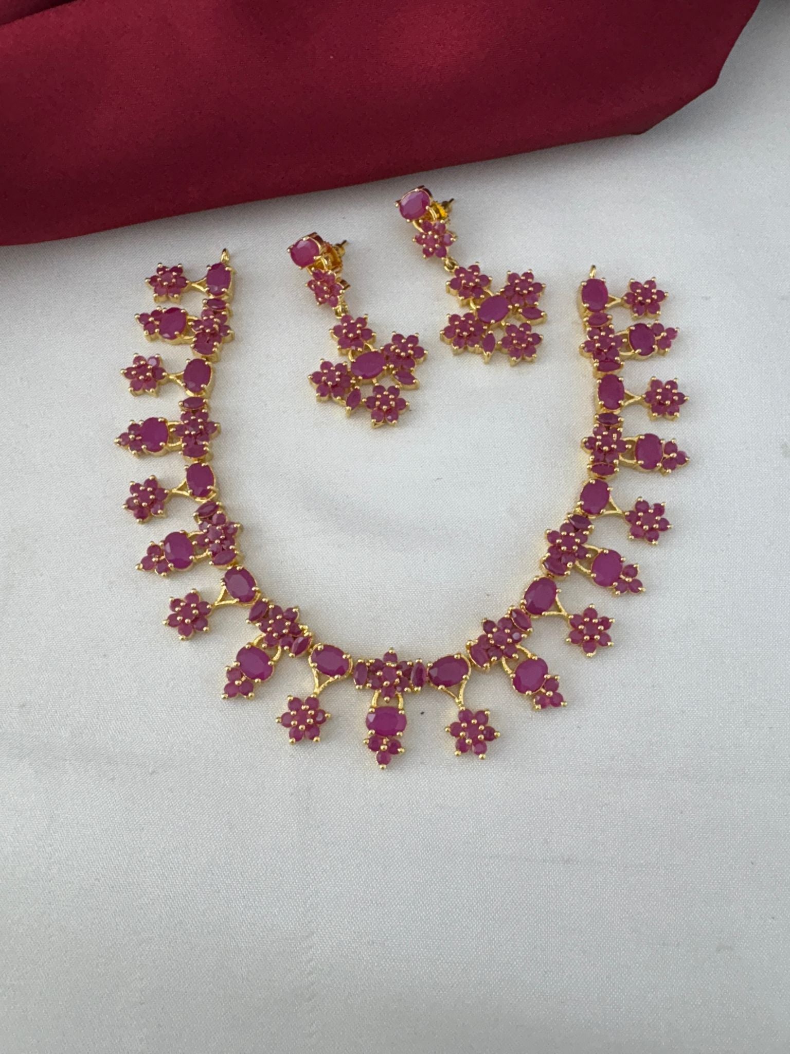 FeelOri Ruby-Tone CZ Short Necklace Set with Nakshi Work. Angled view showcasing the ruby necklace and earrings from the Telangana Art collection by feelori.