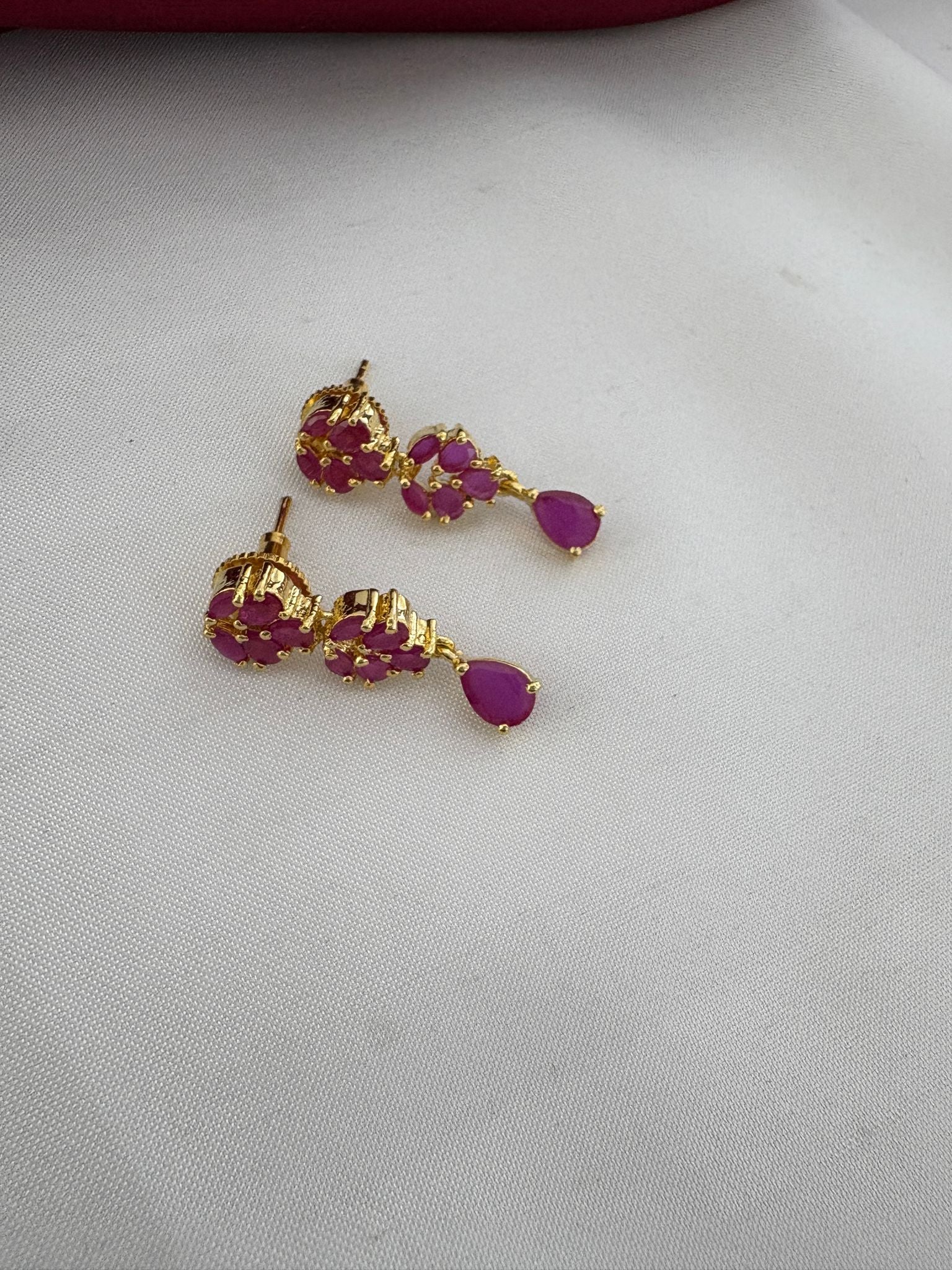 Close-up of FeelOri Regal Ruby-Tone CZ floral earrings - part of the Chennai weddings necklace set.