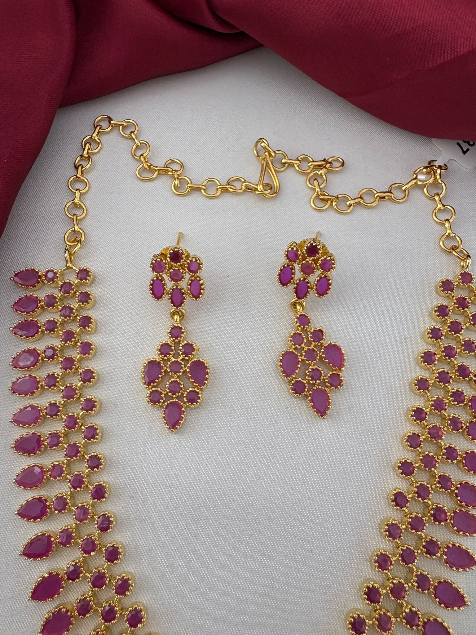 Detailed close-up of FeelOri ruby necklace clasp and matching drop earrings. Showcasing the craftsmanship of the Ruby-Tone CZ Short Necklace Set for Indian Celebrations by FeelOri.