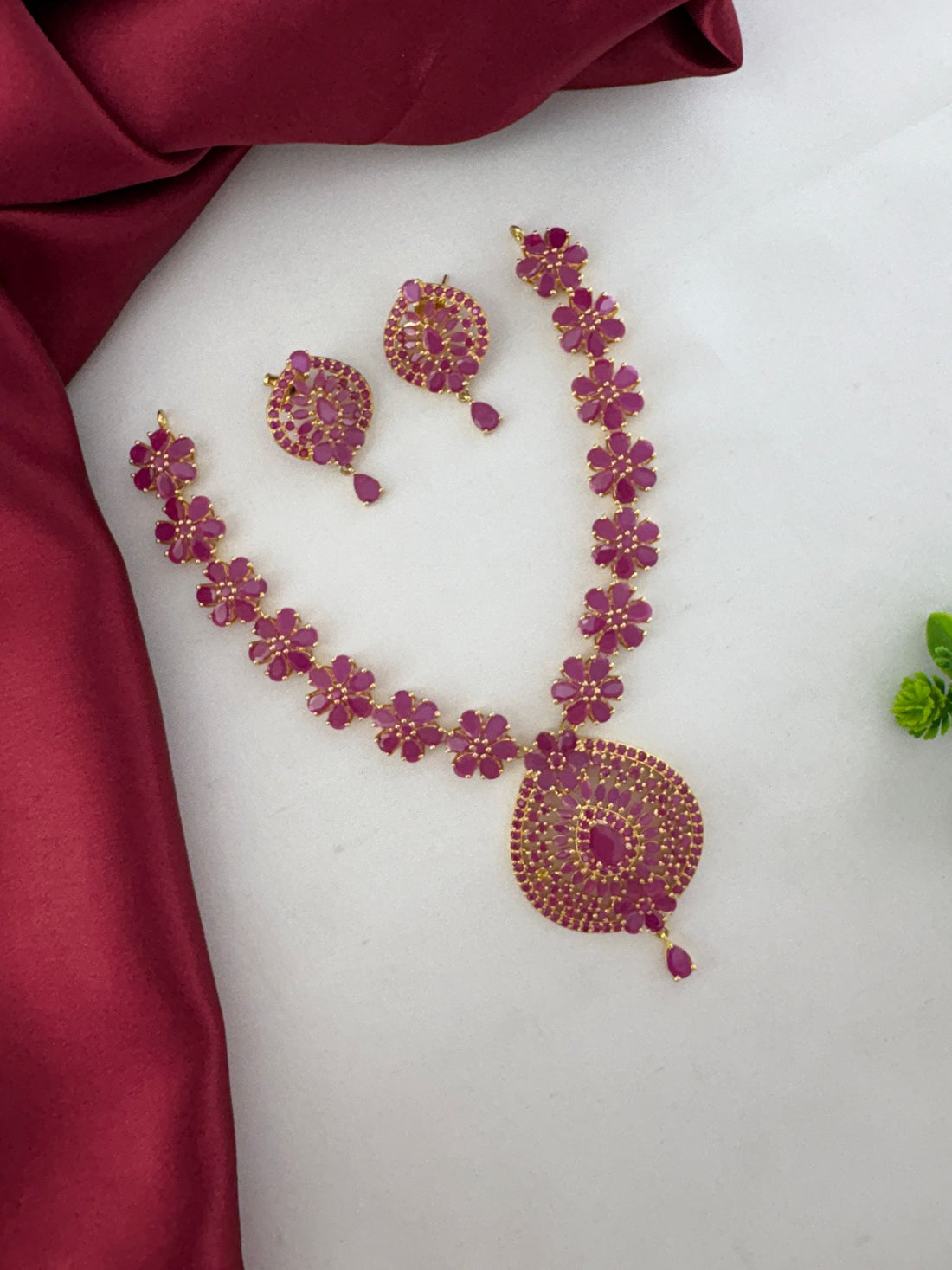 Full view of FeelOri Charming Ruby-Tone CZ Short Necklace Set for Telugu Weddings, with necklace spread out and matching earrings.