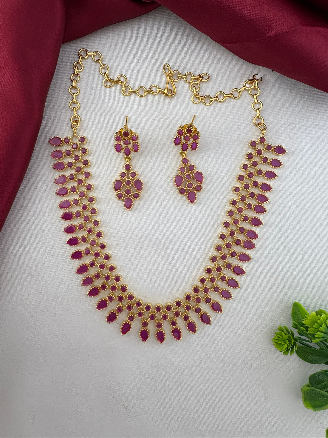 Top view of the FeelOri Festive Wear Ruby-Tone CZ Short Necklace Set, including earrings and clasp detail. Ideal for women attending Indian Celebrations.