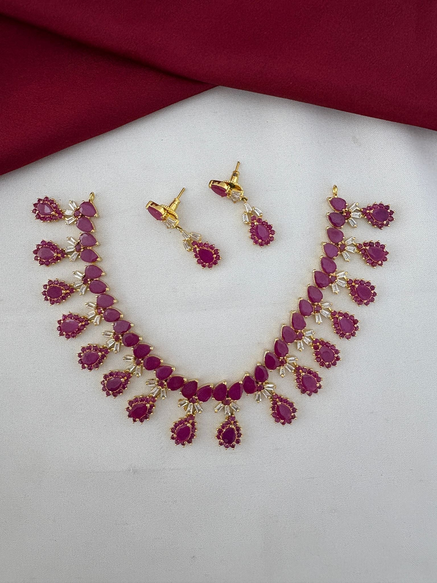 Main image of FeelOri South Indian Ruby-Tone CZ Short Necklace Set, including earrings. Features vibrant ruby stones, designed for Pattu Sarees.