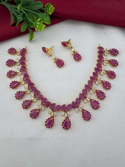 FeelOri South Indian Original Ruby Short Necklace Set displayed with earrings. Styled shot showing the jewellery with a decorative plant element.