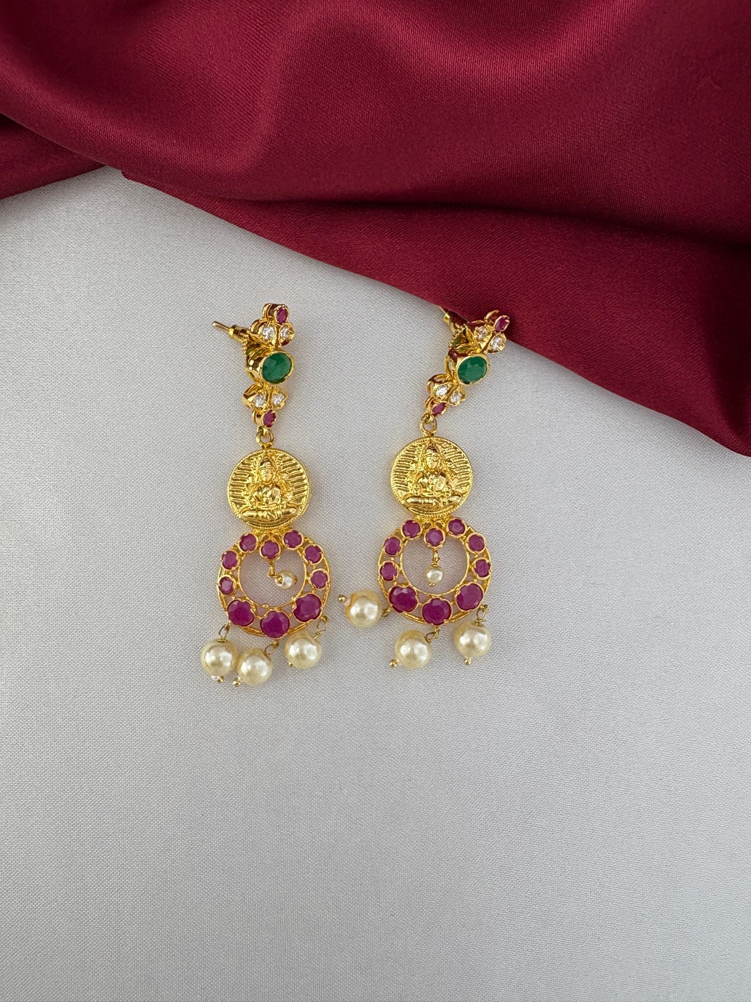 Close-up of FeelOri Sunset Hues Multi-Color AD earrings. Detailed view of gold-plated earrings with red, green, and white AD stones and pearl drops by feelori.