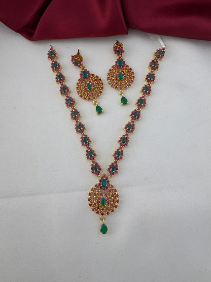 FeelOri Tamil Heritage Twin Stone Ruby & Emerald Short Set - Necklace and Earrings full view on white and maroon background.