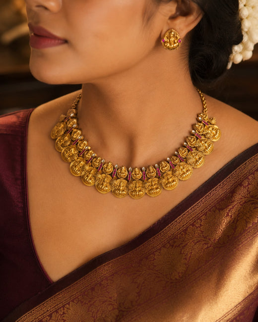 FeelOri gold coin motif jadau kundan necklace set with matching earrings on jewellery display