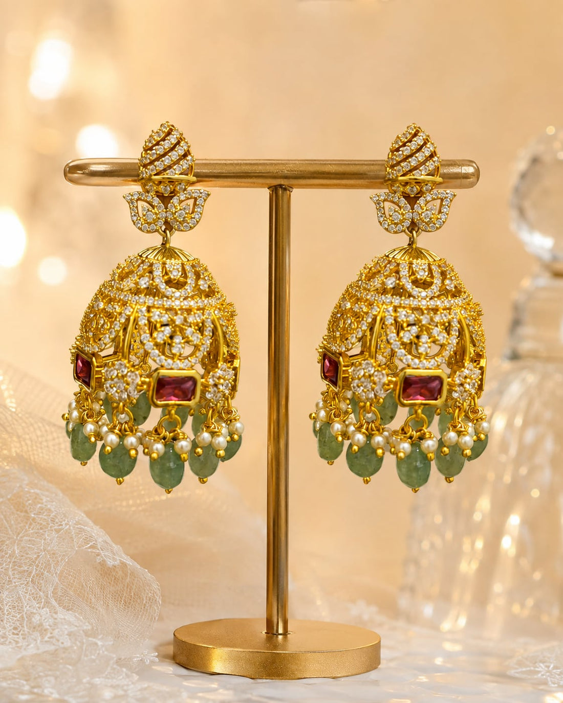 FeelOri gold-plated emerald-drop CZ leaf jhumka earrings displayed as a matching pair