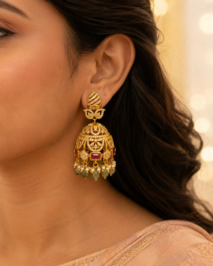 Model wearing FeelOri gold-plated emerald-drop CZ leaf jhumka earrings for Indian occasion styling