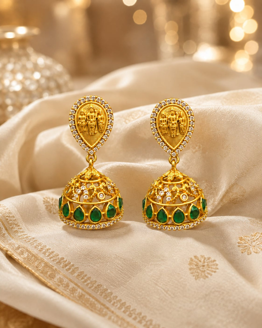 FeelOri gold-plated emerald jhumka earrings styled with saree fabric for Indian occasion wear