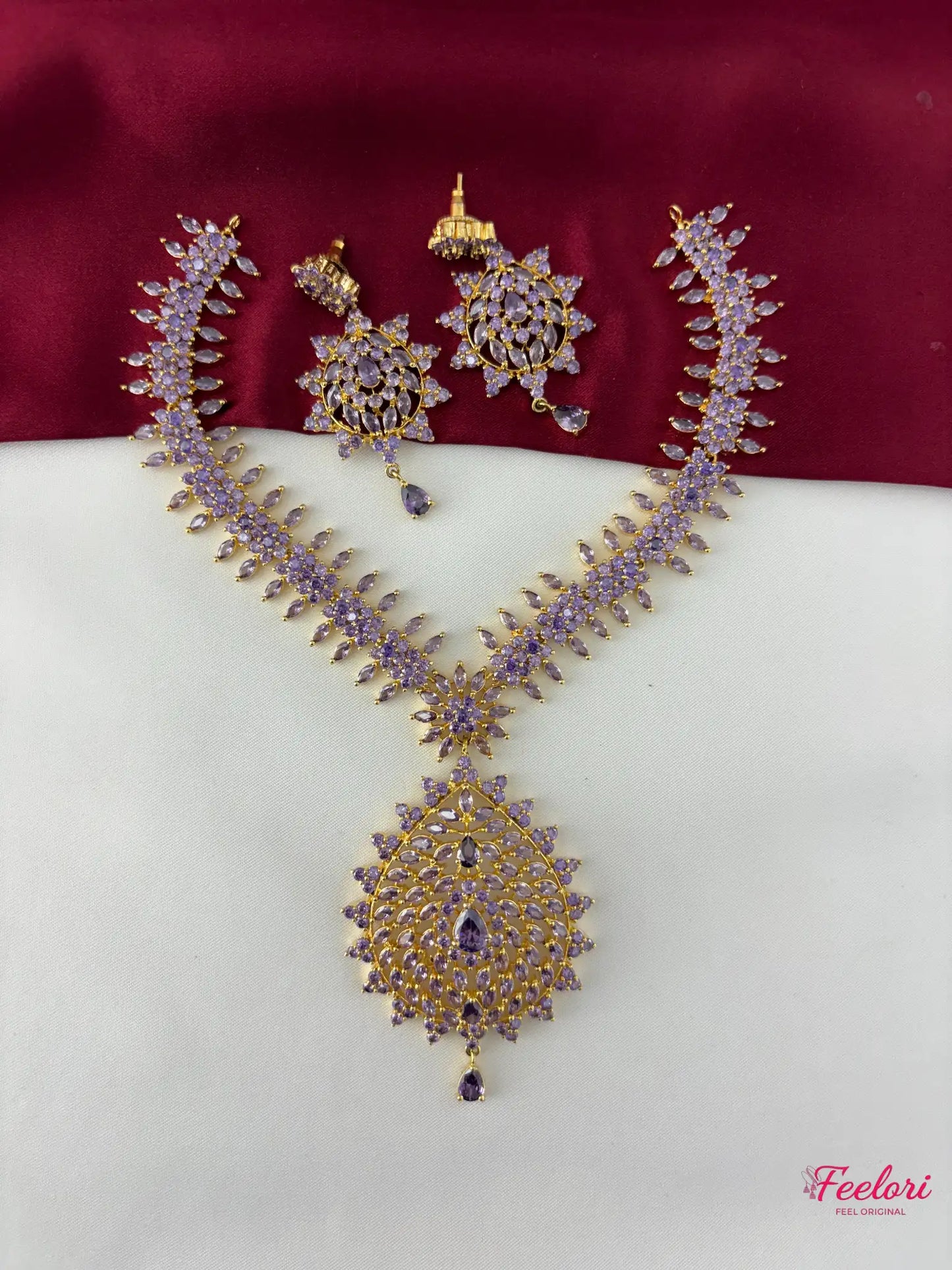 FeelOri gold-plated lavender-tone decorative stone peacock motif necklace set with matching earrings laid out
