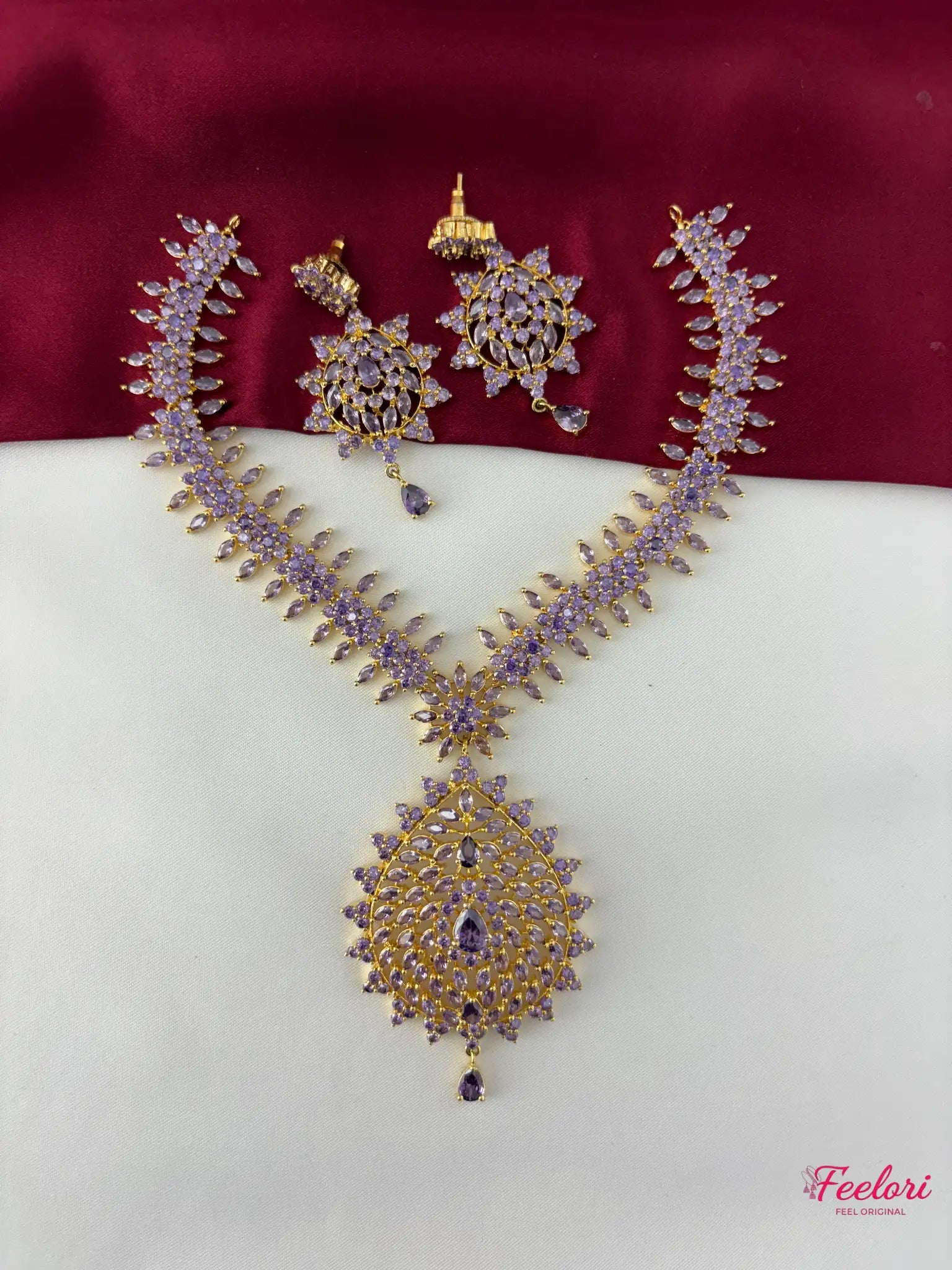FeelOri gold-plated lavender-tone decorative stone peacock motif necklace set with matching earrings laid out