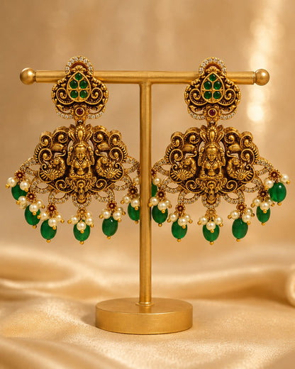 FeelOri gold-plated ruby and emerald earrings on jewellery display