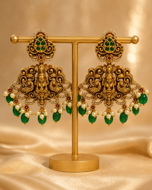 FeelOri gold-plated ruby and emerald earrings on jewellery display