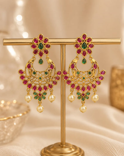 FeelOri gold-plated ruby and emerald earrings on jewellery display