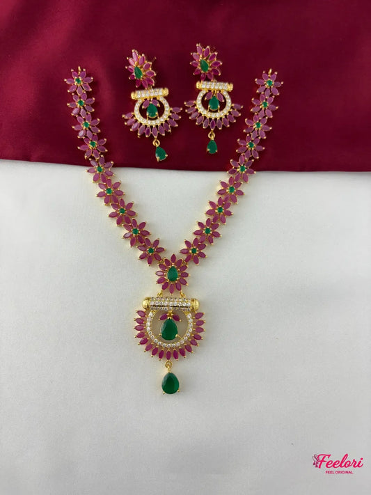 FeelOri Gold Plated Ruby & Emerald Floral Necklace Set - Full front view displaying the intricate flower-shaped linked chain and crescent pendant with a teardrop emerald-like stone.