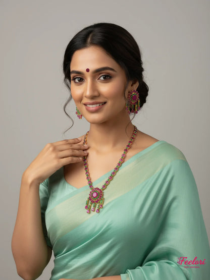 FeelOri Gold Plated Ruby Emerald Floral Petal Necklace Set - Model wearing vibrant set with a light green traditional saree.