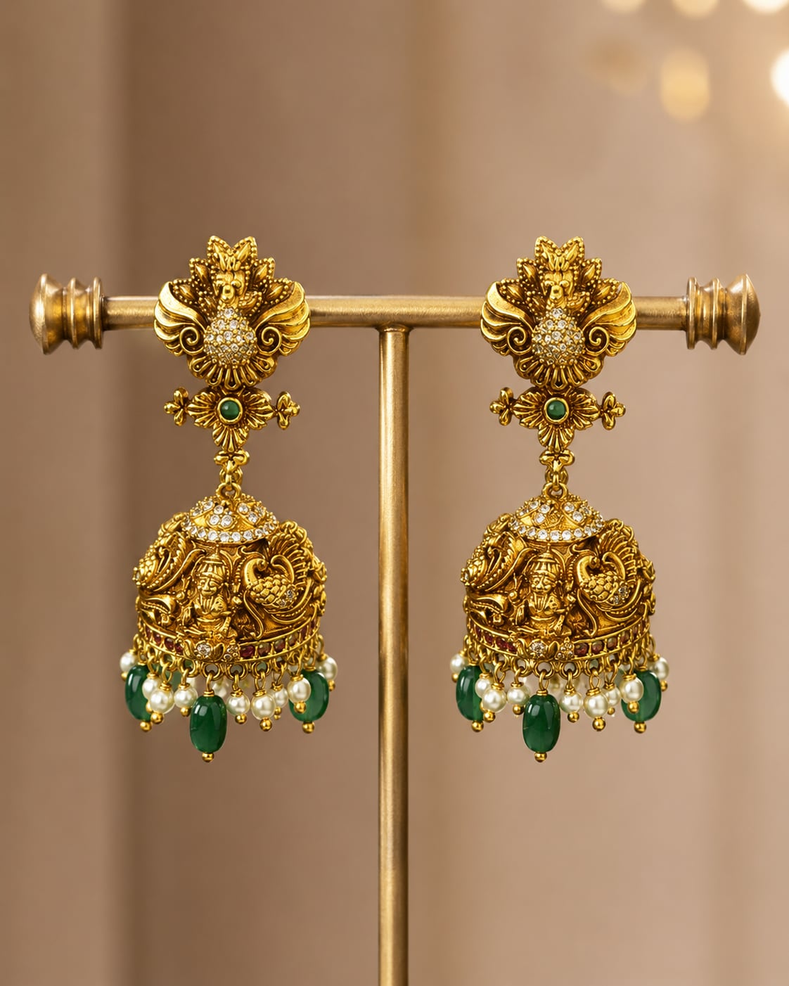 FeelOri gold-plated ruby and emerald jhumka earrings on jewellery display