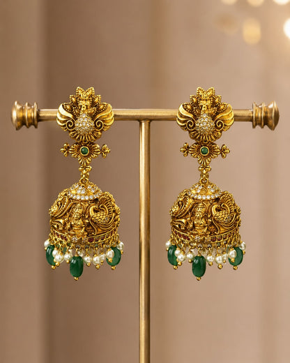 FeelOri gold-plated ruby and emerald jhumka earrings on jewellery display