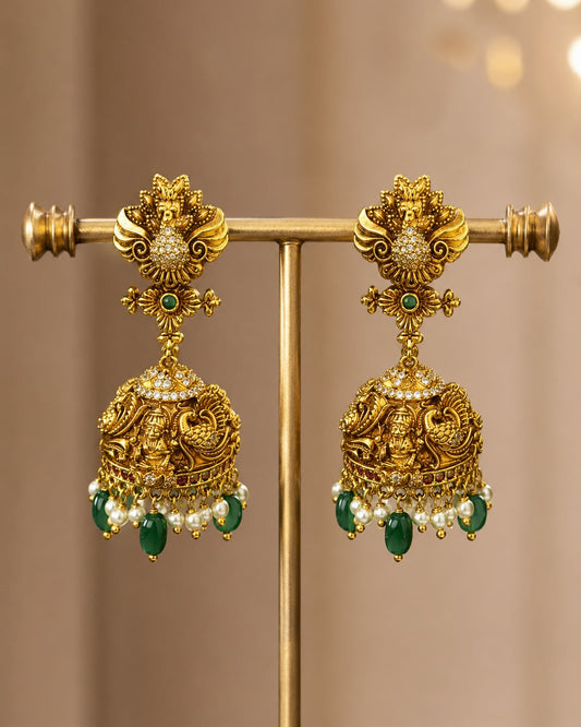 FeelOri gold-plated ruby and emerald jhumka earrings on jewellery display