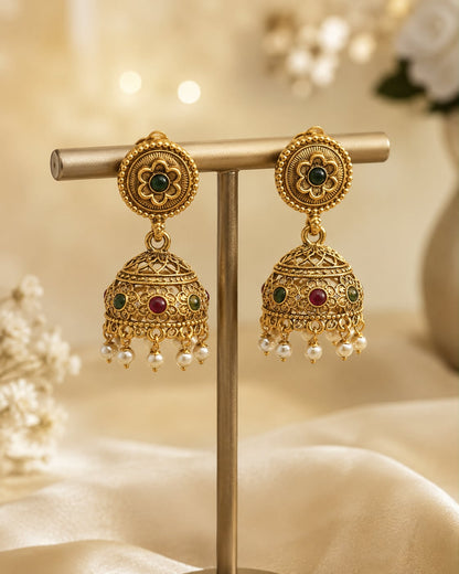 FeelOri gold-plated ruby and emerald jhumka earrings on jewellery display