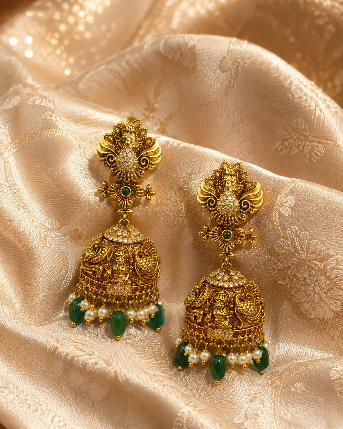 FeelOri gold-plated ruby and emerald jhumka earrings styled with saree fabric for Indian occasion wear