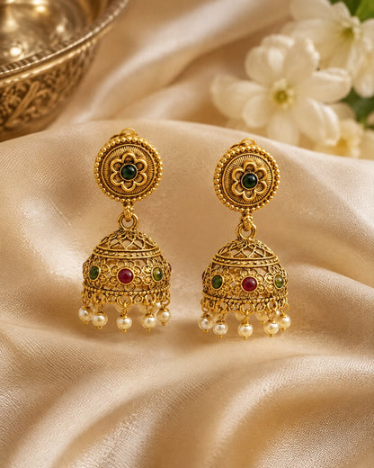 FeelOri gold-plated ruby and emerald jhumka earrings styled with saree fabric for Indian occasion wear
