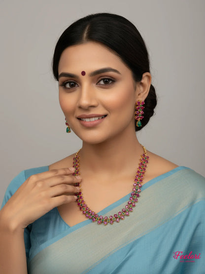 FeelOri Gold Plated Ruby Emerald Leaf Motif Necklace Set - Model wearing set with blue traditional saree, smiling.