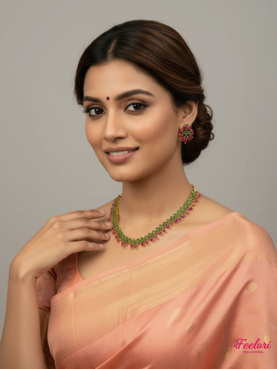 FeelOri Gold Plated Ruby Emerald Tear Drop Necklace Set - Model wearing vibrant set with traditional peach saree.