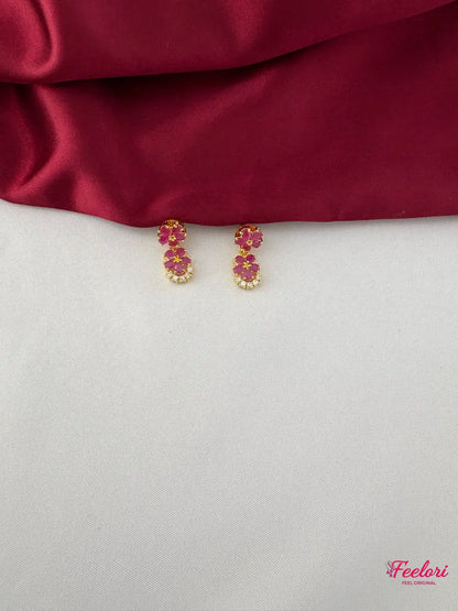 FeelOri Gold Plated Ruby Floral Motif Earrings - Close-up view of the matching earrings, highlighting the two-petal ruby arrangement and clear stone accents.