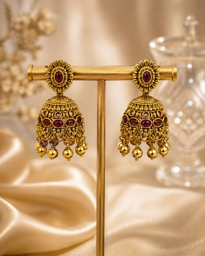 FeelOri gold-plated ruby jhumka earrings on jewellery display