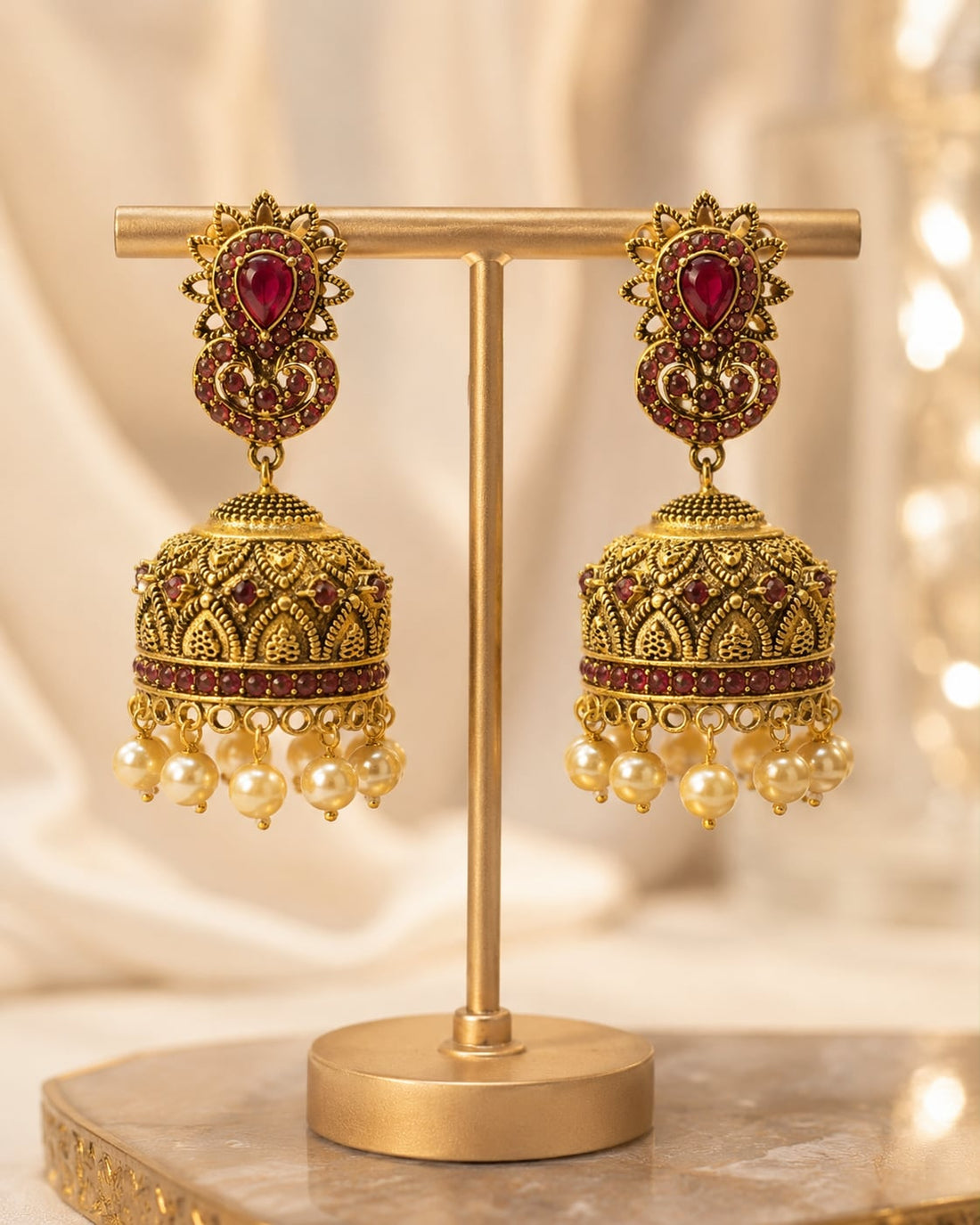 FeelOri gold-plated ruby jhumka earrings on jewellery display
