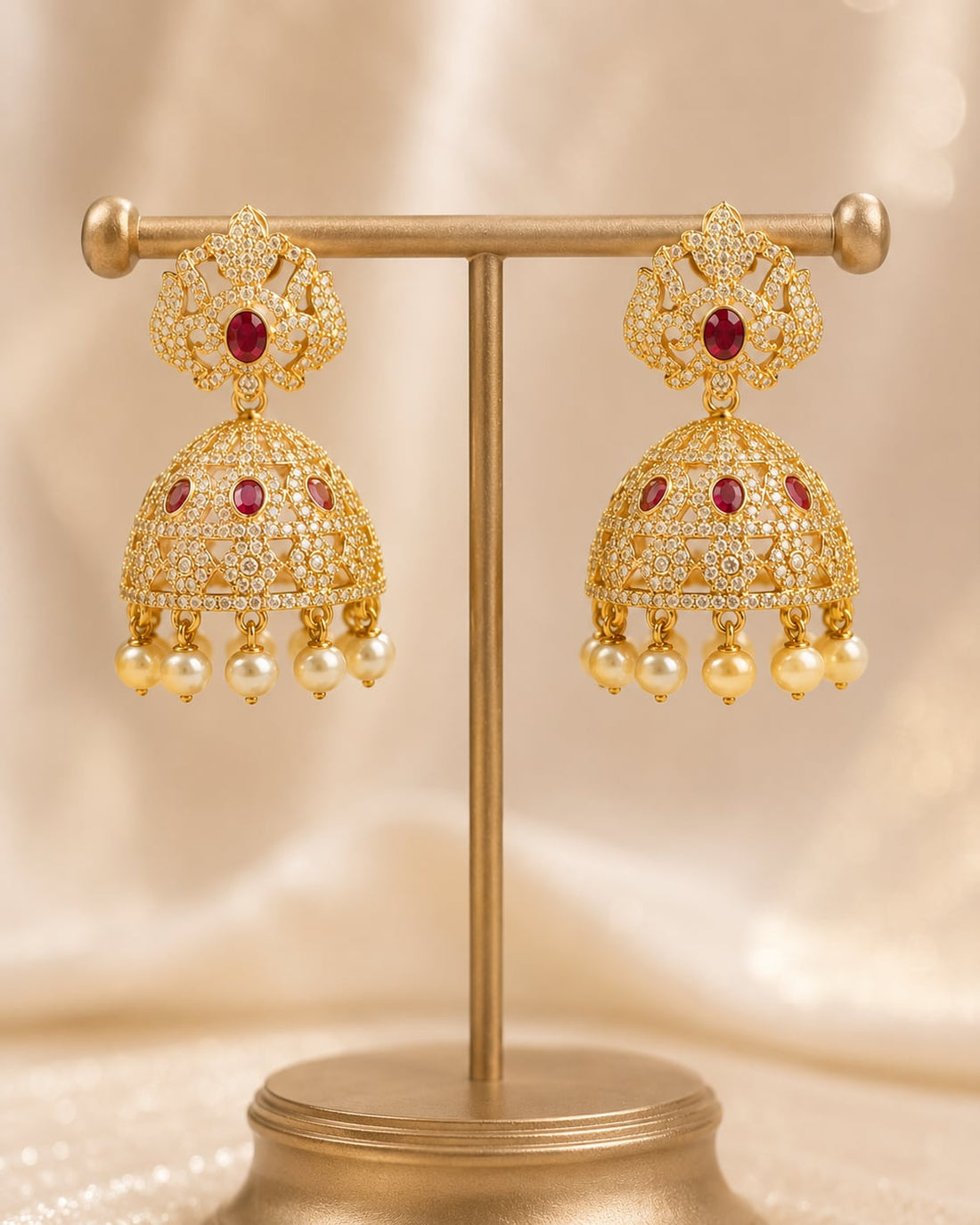 Front view of one matching pair of FeelOri gold-plated ruby crown CZ jhumka earrings with pearl-look fringe